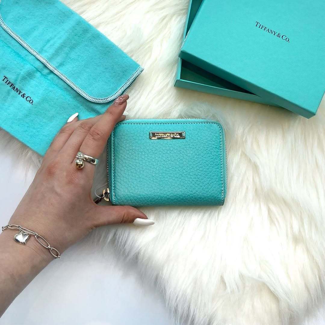 ティファニーブルーの財布を持つ人の手元