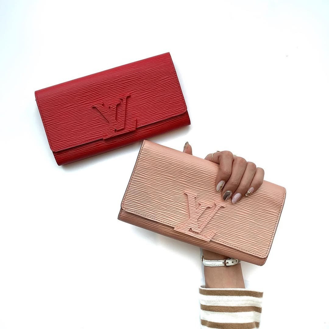 ヴィトンの長財布を持つ女性の手元