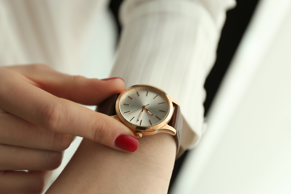 腕時計を調節する女性