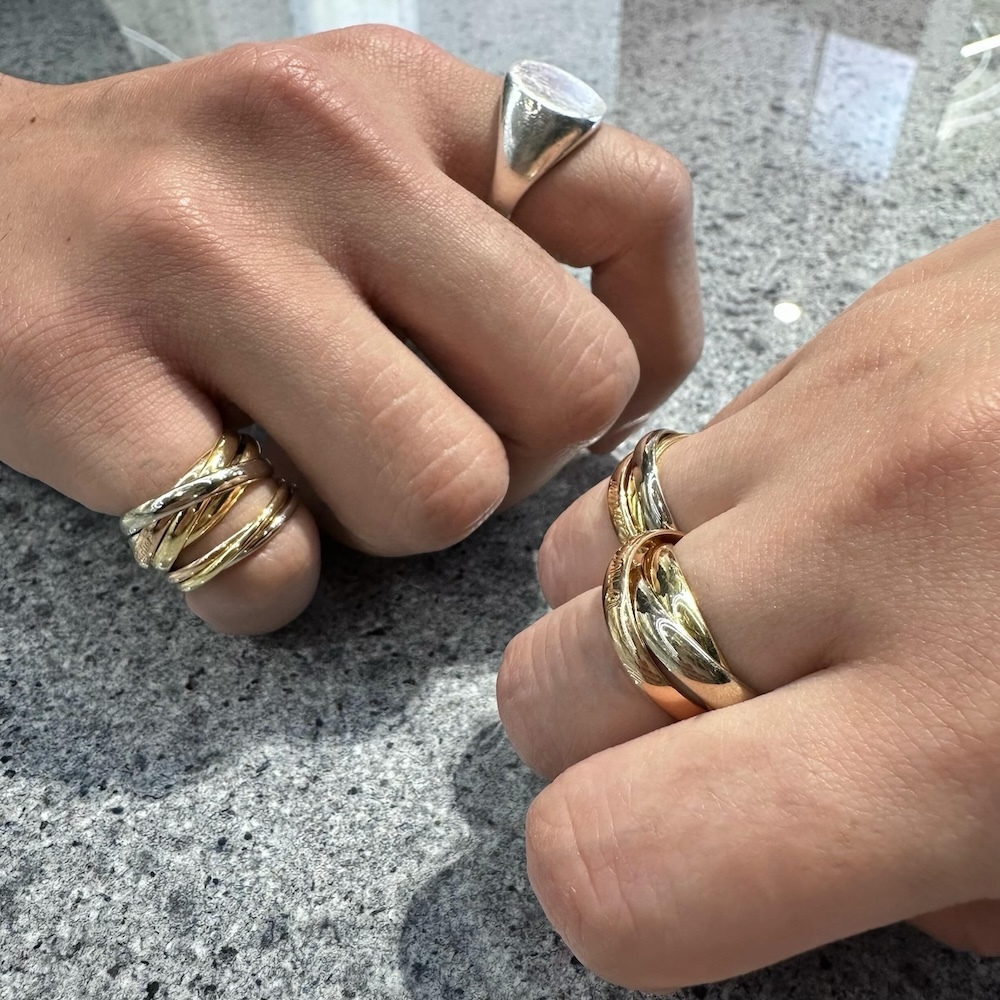 両手で指輪の重ね付けをする人