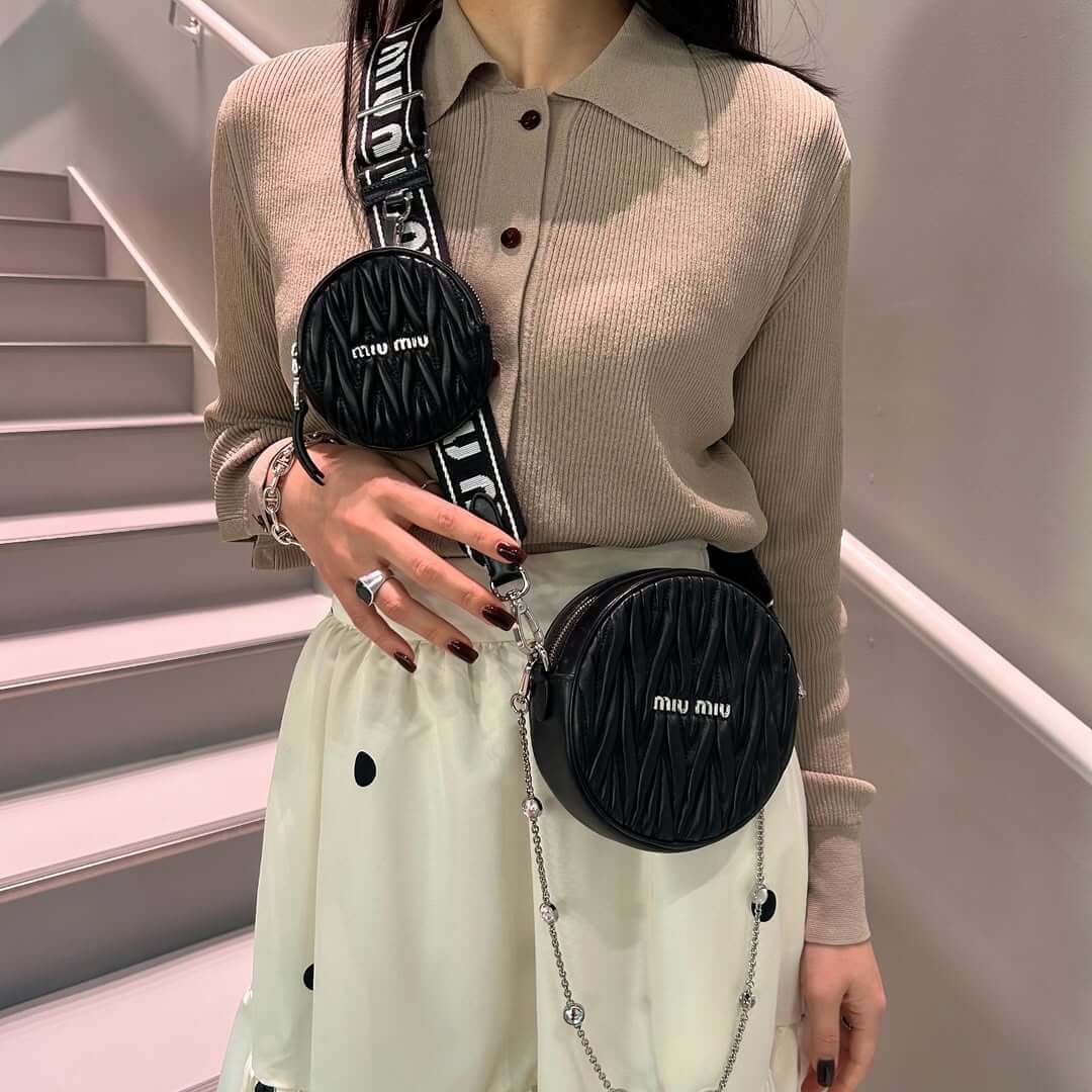 ミュウミュウのバッグチャームを複数付けた女性