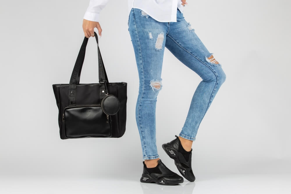 黒いトートバッグを持つカジュアルファッションの女性