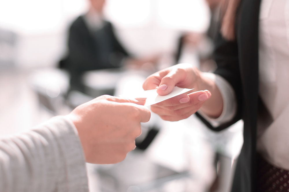 オフィスで名刺交換をする女性