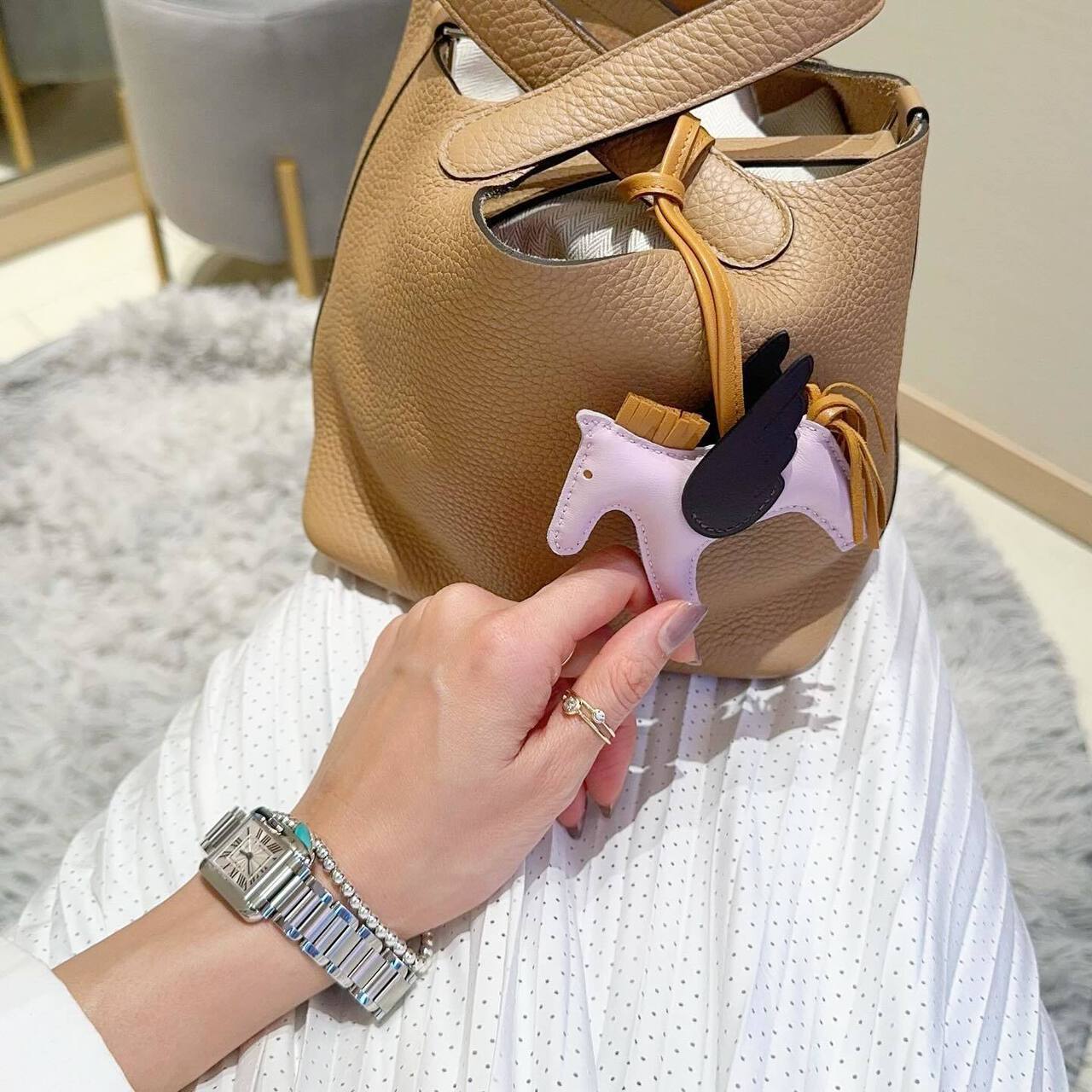 エルメスのバッグを膝に乗せた女性