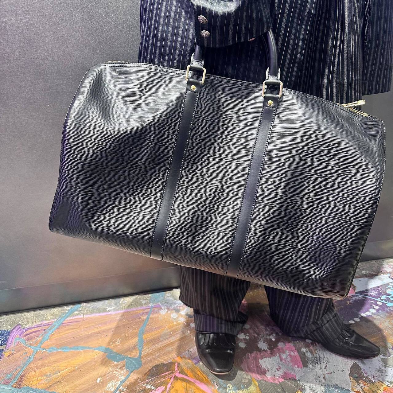 黒のボストンバッグを持った男性