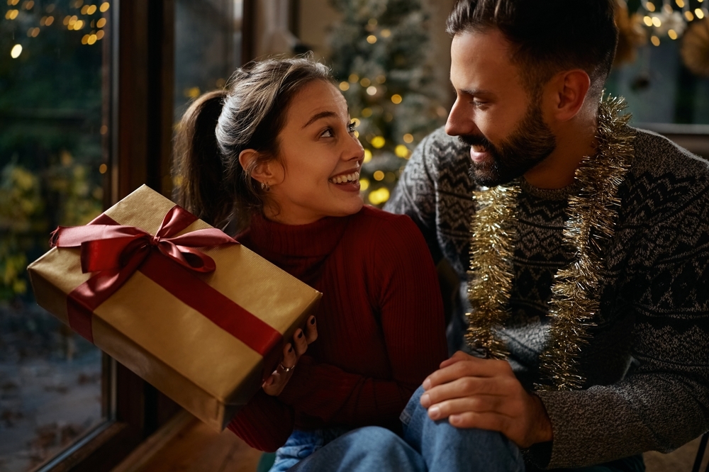 クリスマスにプレゼントを贈る彼氏と喜ぶ彼女