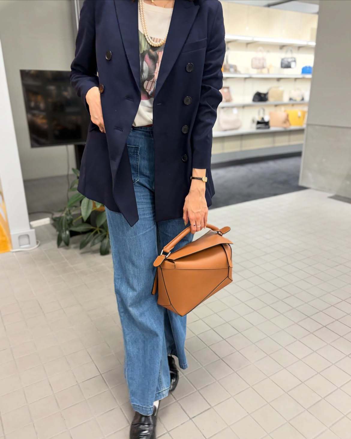 バッグを手に持つジャケットを着た女性