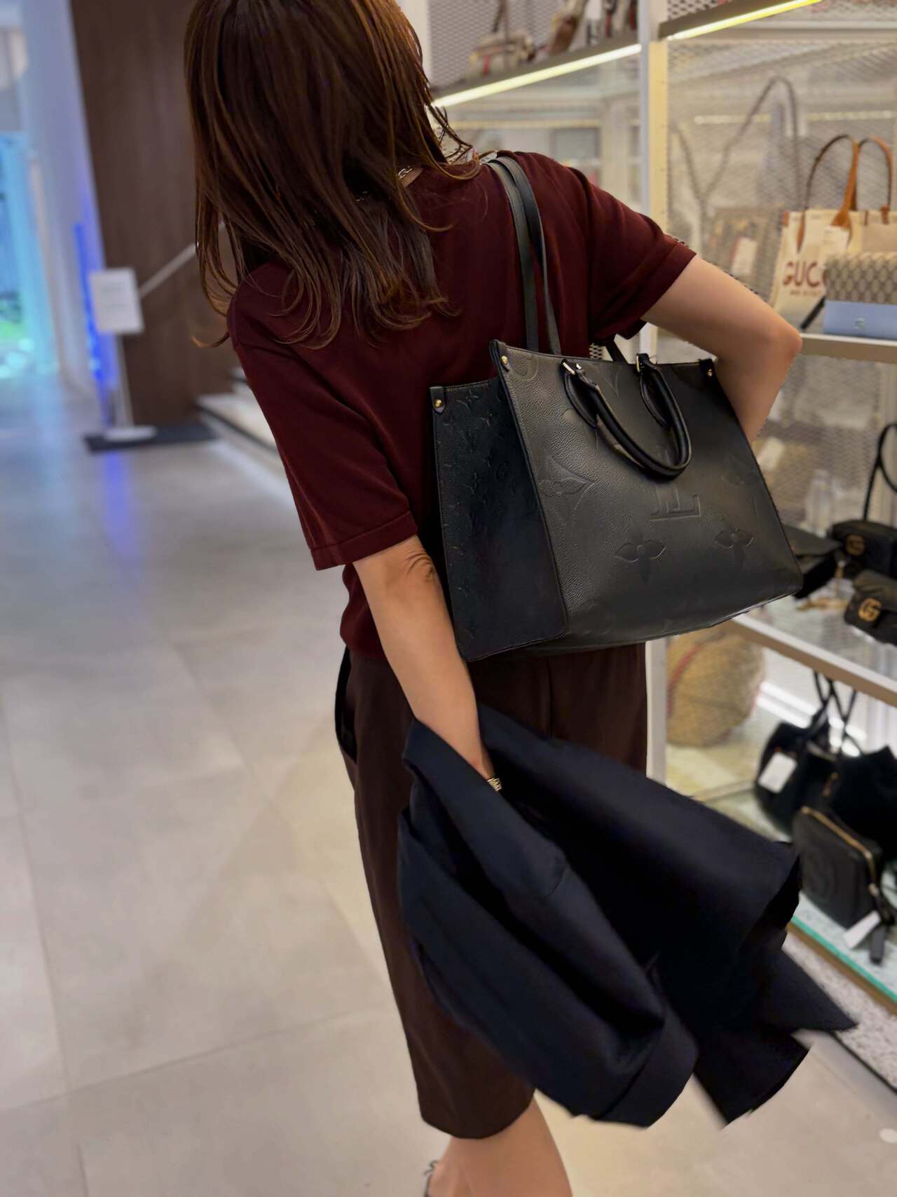 バッグが並ぶ店内を歩くビジネスウーマン