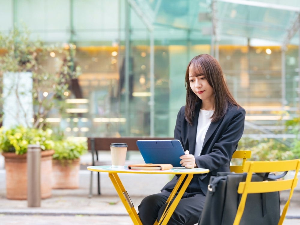 カフェで仕事をするスーツ姿の女性
