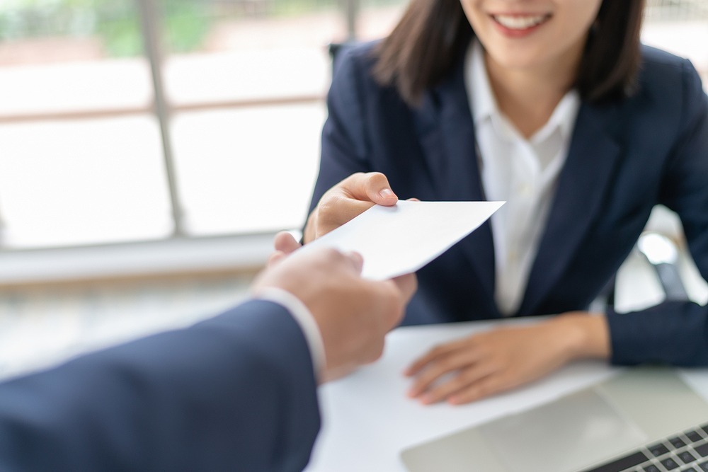 オフィスで封筒を受け取る女性
