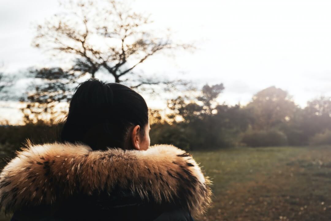 大ぶりのファーストールを巻いた女性の後ろ姿