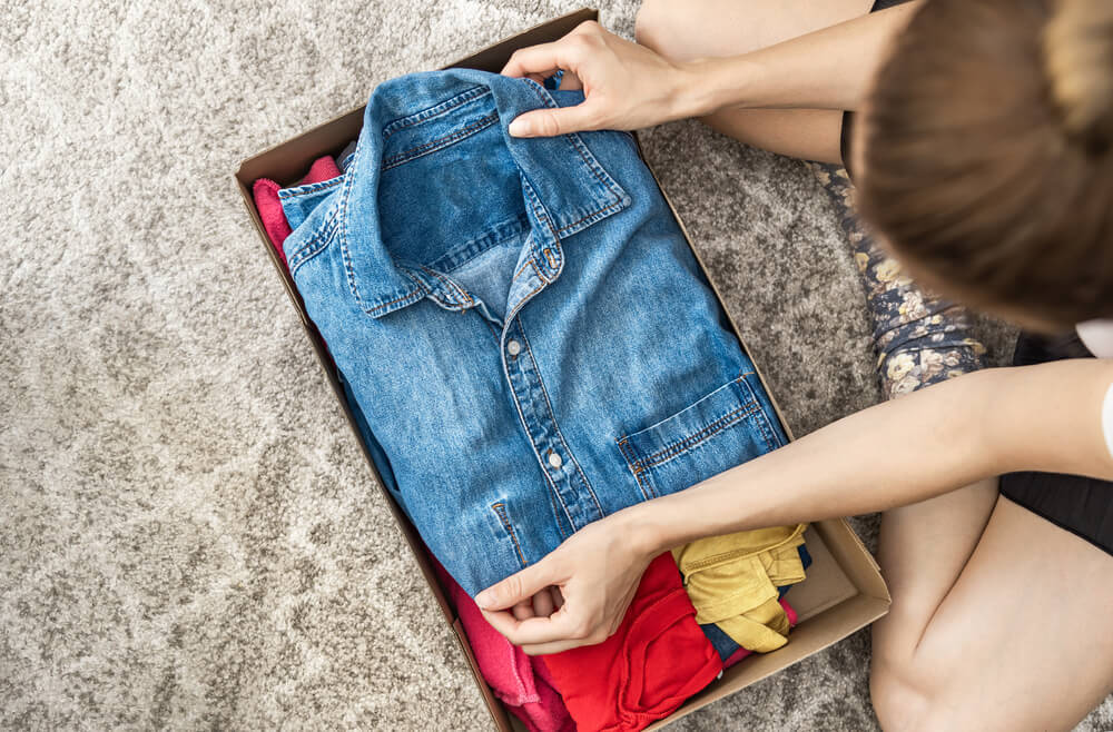 箱に服を詰める女性