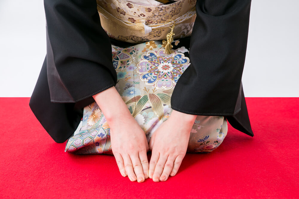 黒留袖でかしこまって挨拶する女性